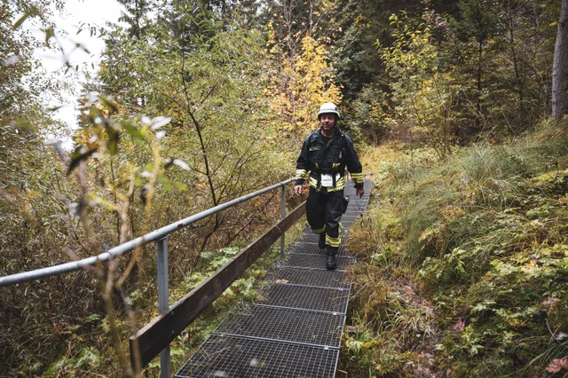 Teilnehmer in schwarzer Einsatzkleidung auf einem Metallsteg.