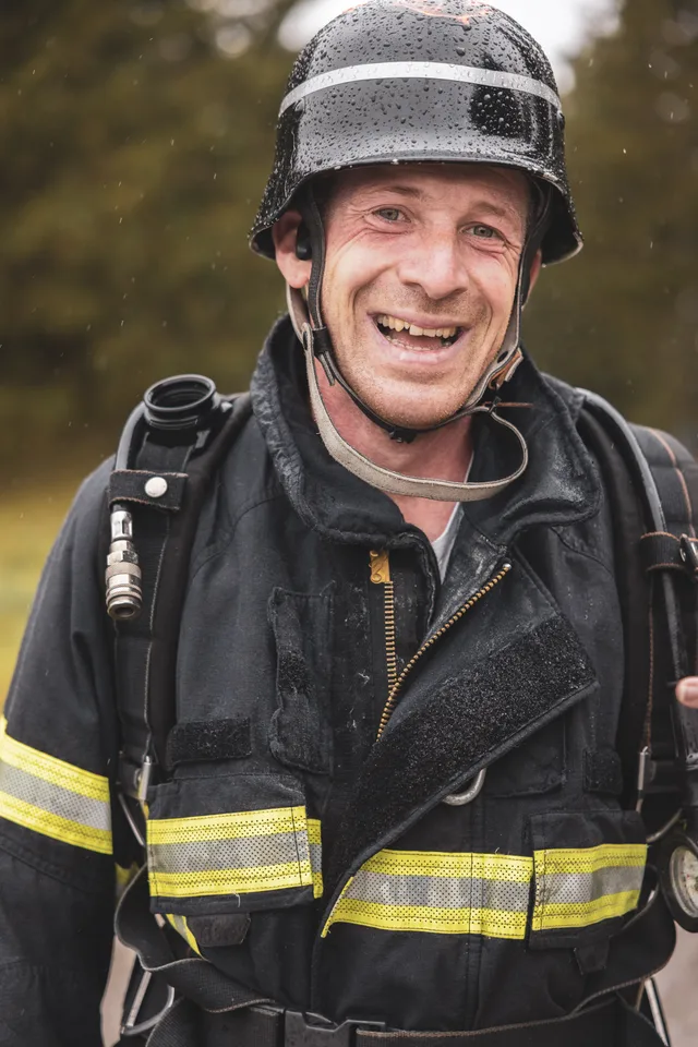 Lachender Teilnehmer mit schwarzem Helm nach dem Zieleinlauf.