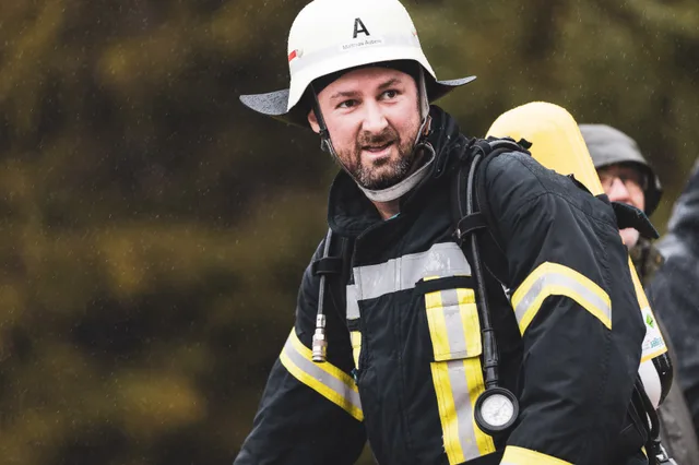 Teilnehmer mit weißem Helm und Bart im Gespräch nach dem Zieleinlauf.